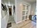 Hallway with wood-look floors, showing entrance to sunroom and pantry with sliding doors at 207 Hawthorne Blvd, Leesburg, FL 34748