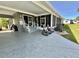 Inviting screened lanai with rocking chairs, planters, and a view of the manicured backyard at 207 Hawthorne Blvd, Leesburg, FL 34748