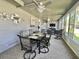 Comfortable sunroom featuring a large table, seating, ceiling fans, and scenic views through expansive windows at 207 Hawthorne Blvd, Leesburg, FL 34748