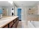 Bathroom featuring a double vanity, soaking tub and glass enclosed shower with tile surround at 20816 Sullivan Ranch Blvd, Mount Dora, FL 32757