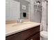 Bathroom with a single sink vanity, framed mirror, and chrome shelving unit above the toilet at 20816 Sullivan Ranch Blvd, Mount Dora, FL 32757
