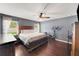 Bedroom features hardwood floors, a ceiling fan, and plenty of natural light from the windows at 20816 Sullivan Ranch Blvd, Mount Dora, FL 32757