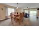 Well-lit dining area featuring a wood table with seating for six, connecting to the living room at 20816 Sullivan Ranch Blvd, Mount Dora, FL 32757