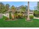 Landscaped front yard with lush green grass, tropical plants, and a well-maintained garden at 20816 Sullivan Ranch Blvd, Mount Dora, FL 32757