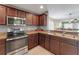 Well-lit kitchen with stainless steel oven, sink, and dark wooden cabinetry at 20816 Sullivan Ranch Blvd, Mount Dora, FL 32757