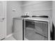 Modern laundry room featuring a front-loading washer and dryer with overhead wire shelving at 20816 Sullivan Ranch Blvd, Mount Dora, FL 32757