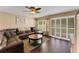 Living room featuring a brown leather sectional, wood floors and sliding doors to the backyard at 20816 Sullivan Ranch Blvd, Mount Dora, FL 32757