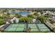 This community features tennis and pickleball courts with a pool and lake in the distance at 2142 Margarita Dr, The Villages, FL 32159