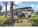 Home featuring a well-maintained backyard with mature trees and lush greenery at 2142 Margarita Dr, The Villages, FL 32159