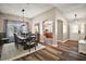 Elegant dining room with dark wood floors, modern light fixture, and an open view into the foyer and kitchen at 2142 Margarita Dr, The Villages, FL 32159