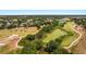 Aerial view displays a lush golf course landscape with trees, ponds, and golf cart paths at 23814 Sardinia Dr, Sorrento, FL 32776