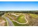 An aerial view showcasing a well-maintained golf course with sand traps and a winding cart path at 23814 Sardinia Dr, Sorrento, FL 32776