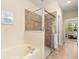 Bright bathroom featuring a soaking tub, a tiled shower, and access to bedroom at 23814 Sardinia Dr, Sorrento, FL 32776