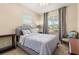 Serene bedroom features a tufted headboard, soft gray tones, and natural light at 23814 Sardinia Dr, Sorrento, FL 32776