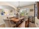 Light-filled dining room with a rustic table, bench seating, and decorative accents at 23814 Sardinia Dr, Sorrento, FL 32776