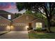 Charming townhome with a two-car garage, lovely landscaping, and a welcoming front entrance at 23814 Sardinia Dr, Sorrento, FL 32776