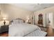 Comfortable main bedroom featuring a bench seat, a nightstand and doorway to bath at 23814 Sardinia Dr, Sorrento, FL 32776