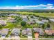 An aerial view features houses in a tranquil neighborhood with sprawling green spaces and community pond at 25545 Laurel Valley Rd, Leesburg, FL 34748