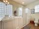Bright bathroom featuring a walk-in tub, glass block window, and a separate glass door shower at 25545 Laurel Valley Rd, Leesburg, FL 34748