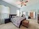 Spacious bedroom with a ceiling fan, a comfortable bed, and mirrored closet doors at 25545 Laurel Valley Rd, Leesburg, FL 34748