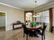 Elegant dining room featuring a chandelier and a dark wood table with seating for four at 25545 Laurel Valley Rd, Leesburg, FL 34748