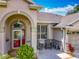 Close up of the front entrance with a red door, seating area, and trimmed shrubbery at 25545 Laurel Valley Rd, Leesburg, FL 34748