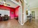 Cozy office space with bright red walls, desk, and ample natural light flowing to kitchen at 25545 Laurel Valley Rd, Leesburg, FL 34748