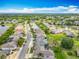A picturesque street view highlighting well-maintained homes, lush landscaping, and a serene pond under a bright blue sky at 25545 Laurel Valley Rd, Leesburg, FL 34748