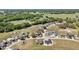 An aerial view of a quiet neighborhood featuring homes surrounded by lush, open green spaces and mature trees at 2581 Se 75Th Blvd, Bushnell, FL 33513