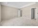 A large bedroom with neutral walls, featuring a tray ceiling and multiple doorways at 2581 Se 75Th Blvd, Bushnell, FL 33513
