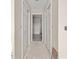 A hallway with white doors on either side and gray tile flooring visible through an open doorway at 2581 Se 75Th Blvd, Bushnell, FL 33513