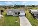 Aerial view of home featuring a driveway, lush lawn, and vibrant landscaping at 25818 Belle Alliance, Leesburg, FL 34748