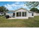 Back of the house featuring a sunroom and patio with a grill and outdoor seating at 25818 Belle Alliance, Leesburg, FL 34748