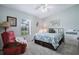 Cozy bedroom featuring a comfortable queen-size bed, recliner, and a bright window view at 25818 Belle Alliance, Leesburg, FL 34748