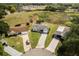 Overhead view of well-maintained home featuring a long driveway, verdant lawn, and a detached carport at 25818 Belle Alliance, Leesburg, FL 34748