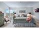 Inviting main bedroom with beach art, soft carpet, a ceiling fan, and windows that offer a bright and airy feel at 25818 Belle Alliance, Leesburg, FL 34748