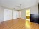 Bedroom with wood flooring, ceiling fan and plenty of storage, including a large closet, and an exterior entrance at 26823 Forest Hills St, Leesburg, FL 34788