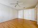 Bedroom with wood floors, ceiling fan and a built-in closet, white paneling and a double set of closet doors at 26823 Forest Hills St, Leesburg, FL 34788