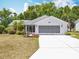 Charming single-story home with a well-manicured lawn and screened garage door at 26823 Forest Hills St, Leesburg, FL 34788