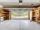 Spacious garage with storage and shelves, offering a clear view of the street through an open garage door at 26823 Forest Hills St, Leesburg, FL 34788