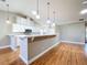 Well-lit kitchen features white cabinets, a breakfast bar, and wood-look floors at 26823 Forest Hills St, Leesburg, FL 34788