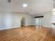 Bright living room with wood floors, skylight, ceiling fan, and access to the patio at 26823 Forest Hills St, Leesburg, FL 34788