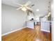 Open-concept living room with hardwood floors, ceiling fan and views of the kitchen with stainless appliances at 26823 Forest Hills St, Leesburg, FL 34788