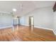 Large living room with wood flooring, a ceiling fan, and a bright skylight at 26823 Forest Hills St, Leesburg, FL 34788