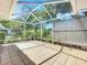 A screened-in patio features tile flooring and a lattice accent wall offering a relaxing outdoor living space at 26823 Forest Hills St, Leesburg, FL 34788