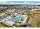 Aerial view of the community pool area with sun loungers, palm trees, and well-maintained landscaping at 2775 Navy Hill Cir, The Villages, FL 32163