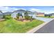 Well-manicured front yard with lush green grass, ornamental shrubs, and a beautifully maintained landscape at 2775 Navy Hill Cir, The Villages, FL 32163