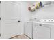 Efficient laundry room featuring white washer, dryer and storage shelves at 2775 Navy Hill Cir, The Villages, FL 32163