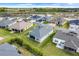 A sunny aerial view of the home showcasing a well-maintained lawn and screened-in patio for outdoor living at 2775 Navy Hill Cir, The Villages, FL 32163