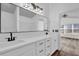 Bathroom with double sink vanity, large mirror and black fixtures with wood style flooring at 2988 Santa Maria Ave, Clermont, FL 34715